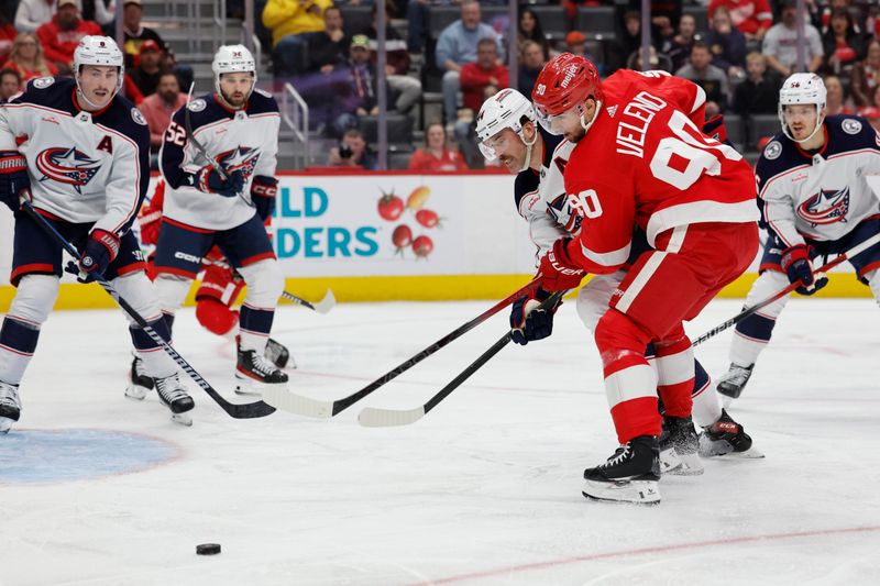 Nov 11, 2023; Detroit, Michigan, USA;  Columbus Blue Jackets defenseman Erik Gudbranson (44) and Detroit Red Wings center Joe Veleno (90) battle for the puck in the second period at Little Caesars Arena. Mandatory Credit: Rick Osentoski-USA TODAY Sports