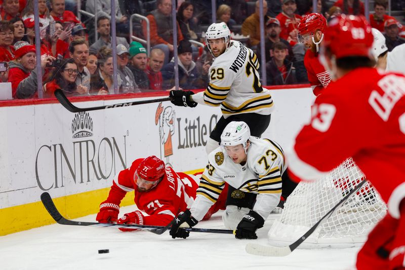 Dec 31, 2023; Detroit, Michigan, USA; Boston Bruins defenseman Charlie McAvoy (73) fights for control of the puck with Detroit Red Wings center Dylan Larkin (71) during the second period of the game between the Boston Bruins and the Detroit Red Wings at Little Caesars Arena. Mandatory Credit: Brian Bradshaw Sevald-USA TODAY Sports