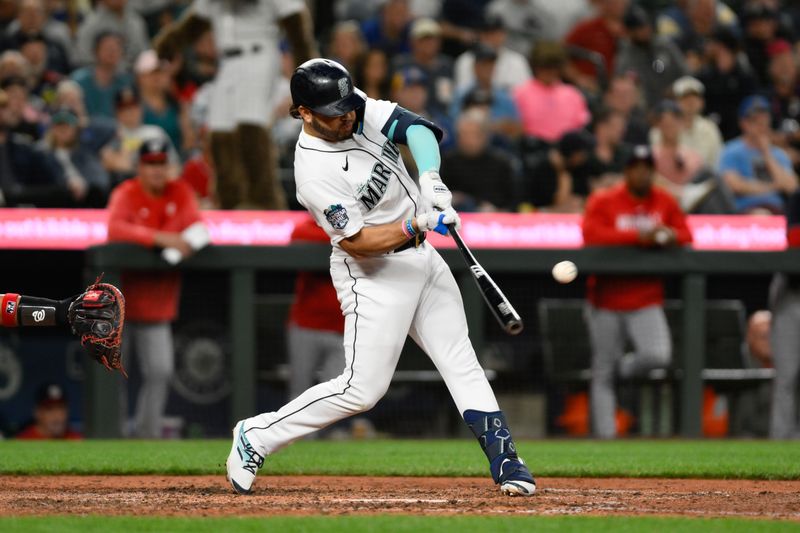 Jun 27, 2023; Seattle, Washington, USA; Seattle Mariners third baseman Eugenio Suarez (28) hits a double against the Washington Nationals during the ninth inning at T-Mobile Park. Mandatory Credit: Steven Bisig-USA TODAY Sports