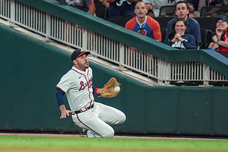 Aug 20, 2024; Cumberland, Georgia, USA; Atlanta Braves right fielder Ramon Laureano (18) makes a sliding catch on a ball hit by Philadelphia Phillies right fielder Nick Castellanos (8) (not shown) during the ninth inning at Truist Park. Mandatory Credit: Dale Zanine-USA TODAY Sports