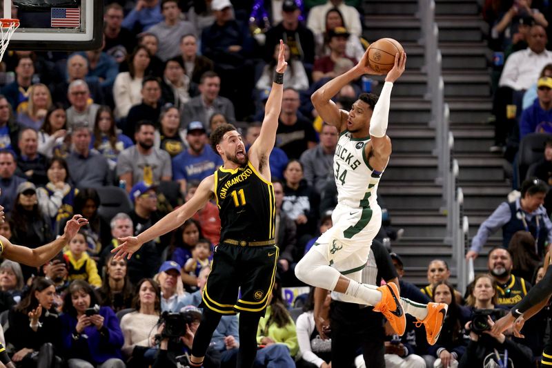 SAN FRANCISCO, CALIFORNIA - MARCH 06: Giannis Antetokounmpo #34 of the Milwaukee Bucks passes the ball around Klay Thompson #11 of the Golden State Warriors in the second half at Chase Center on March 06, 2024 in San Francisco, California. NOTE TO USER: User expressly acknowledges and agrees that, by downloading and or using this photograph, User is consenting to the terms and conditions of the Getty Images License Agreement.  (Photo by Ezra Shaw/Getty Images)