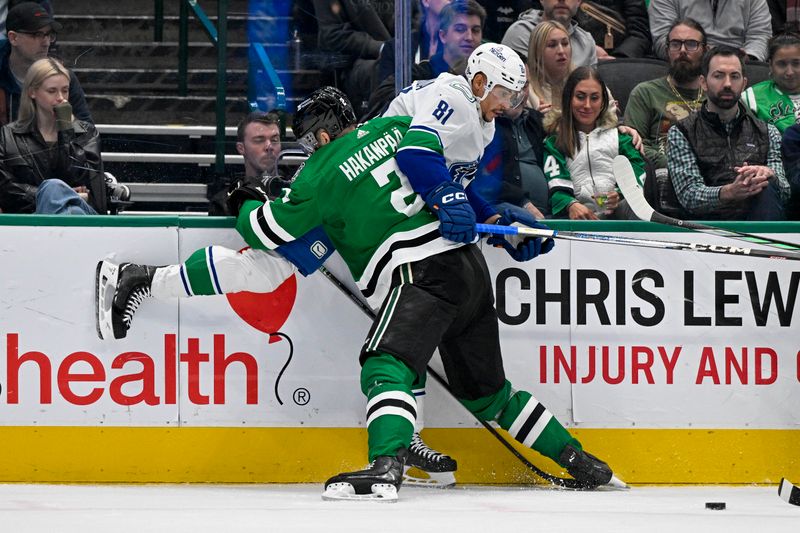 Dec 21, 2023; Dallas, Texas, USA; Dallas Stars defenseman Jani Hakanpaa (2) checks Vancouver Canucks center Dakota Joshua (81) during the third period at the American Airlines Center. Mandatory Credit: Jerome Miron-USA TODAY Sports