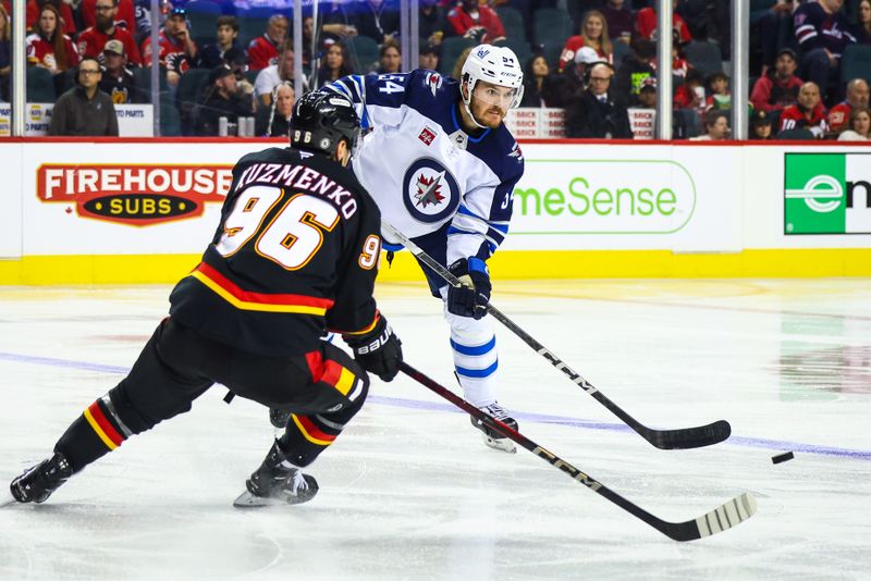 Oct 26, 2024; Calgary, Alberta, CAN; Winnipeg Jets defenseman Dylan Samberg (54) controls the puck against the Calgary Flames during the third period at Scotiabank Saddledome. Mandatory Credit: Sergei Belski-Imagn Images