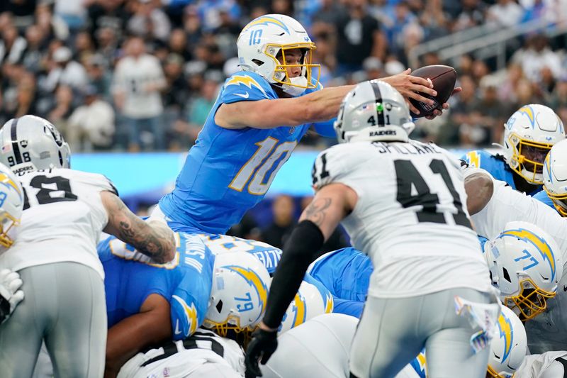 Los Angeles Chargers quarterback Justin Herbert (10) lunges into the end zone for a touchdown during the first half of an NFL football game against the Las Vegas Raiders Sunday, Oct. 1, 2023, in Inglewood, Calif. (AP Photo/Ashley Landis)