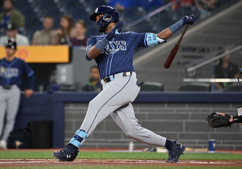 May 14, 2025; Toronto, Ontario, CAN;  Tampa Bay Rays third baseman Junior Caminero (13) hits a single against the Toronto Blue Jays in the first inning at Rogers Centre. Mandatory Credit: Dan Hamilton-Imagn Images