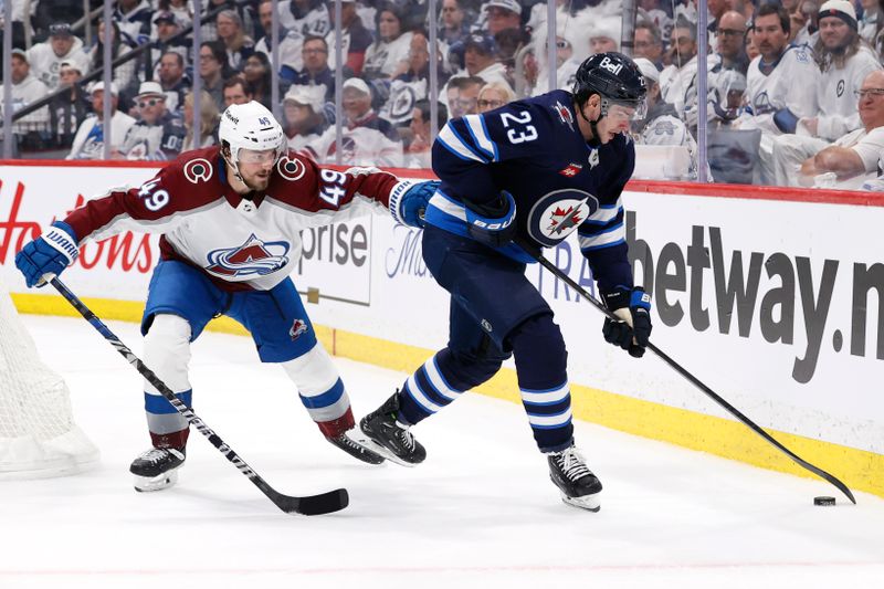 Apr 30, 2024; Winnipeg, Manitoba, CAN;Winnipeg Jets center Sean Monahan (23) is checked by Colorado Avalanche defenseman Samuel Girard (49) in the second period in game five of the first round of the 2024 Stanley Cup Playoffs at Canada Life Centre. Mandatory Credit: James Carey Lauder-USA TODAY Sports