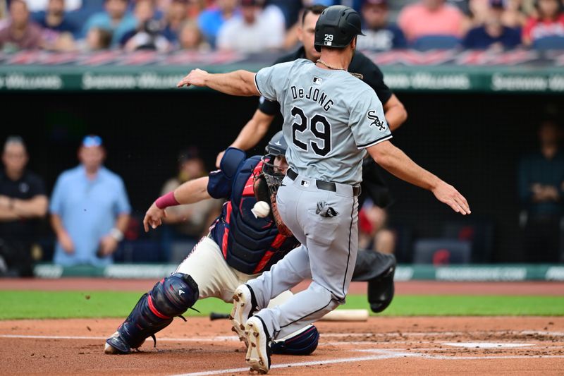 Jul 2, 2024; Cleveland, Ohio, USA; Chicago White Sox shortstop Paul DeJong (29) slides into home as Cleveland Guardians catcher Austin Hedges (27) waits for the throw during the second inning at Progressive Field. DeJong was out on the play. Mandatory Credit: Ken Blaze-USA TODAY Sports