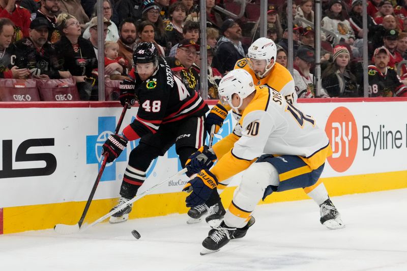 Nov 28, 2025; Chicago, Illinois, USA; Nashville Predators center Fedor Svechkov (40) defends against Chicago Blackhawks defenseman Matt Grzelcyk (48) during the first period at United Center. Mandatory Credit: David Banks-Imagn Images
