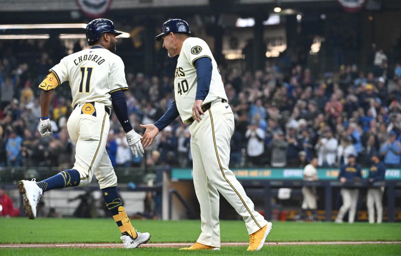 Apr 3, 2024; Milwaukee, Wisconsin, USA; Milwaukee Brewers right fielder Jackson Chourio (11) is congratulated by third base coach Jason Lane after hitting his first Major League home run against the Minnesota Twins in the fifth inning at American Family Field. Mandatory Credit: Michael McLoone-USA TODAY Sports