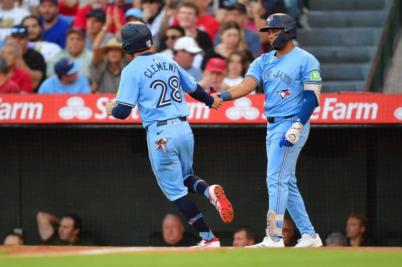 Aug 13, 2024; Anaheim, California, USA; Toronto Blue Jays third baseman Ernie Clement (28) is greeted by Toronto Blue Jays shortstop Leo Jimenez (49) after scoring a run against the Los Angeles Angels during the first inning at Angel Stadium. Mandatory Credit: Gary A. Vasquez-USA TODAY Sports