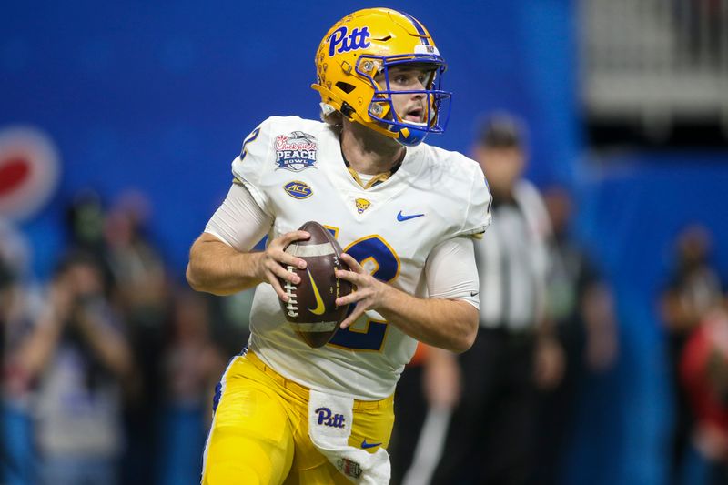 Dec 30, 2021; Atlanta, GA, USA; Pittsburgh Panthers quarterback Nick Patti (12) rolls out to pass against the Michigan State Spartans in the first quarter during the 2021 Peach Bowl at Mercedes-Benz Stadium. Mandatory Credit: Brett Davis-USA TODAY Sports