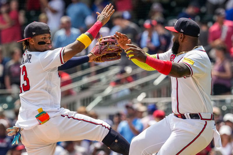 Aug 2, 2023; Cumberland, Georgia, USA; Atlanta Braves outfielder Ronald Acuna Jr. (13) reacts with designated hitter Marcell Ozuna (20) after the Braves defeated the Los Angeles Angels at Truist Park. Mandatory Credit: Dale Zanine-USA TODAY Sports