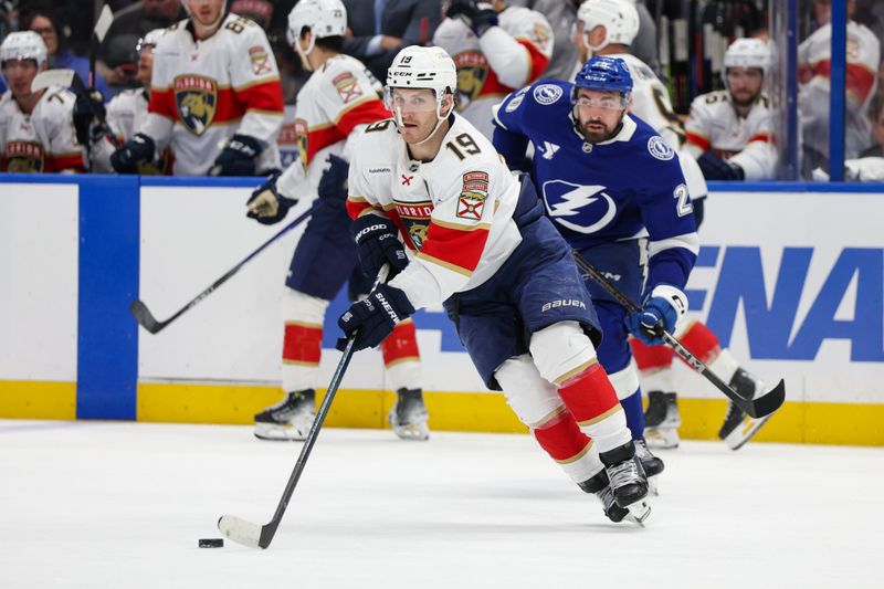 Apr 24, 2025; Tampa, Florida, USA; Florida Panthers left wing Matthew Tkachuk (19) controls the puck against the Tampa Bay Lightning during the third period in game two of the first round of the 2025 Stanley Cup Playoffs at Amalie Arena. Mandatory Credit: Nathan Ray Seebeck-Imagn Images