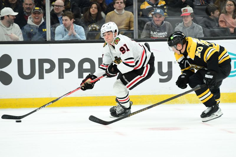 Apr 10, 2025; Boston, Massachusetts, USA; Chicago Blackhawks center Frank Nazar (91) skates with the puck while Boston Bruins defenseman Henri Jokiharju (20) gives chase during the second period at TD Garden. Mandatory Credit: Bob DeChiara-Imagn Images