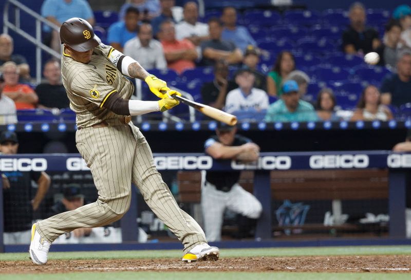 Aug 9, 2024; Miami, Florida, USA;  San Diego Padres third baseman Manny Machado (13) hits a two-run double against the Miami Marlins in the tenth inning at loanDepot Park. Mandatory Credit: Rhona Wise-USA TODAY Sports