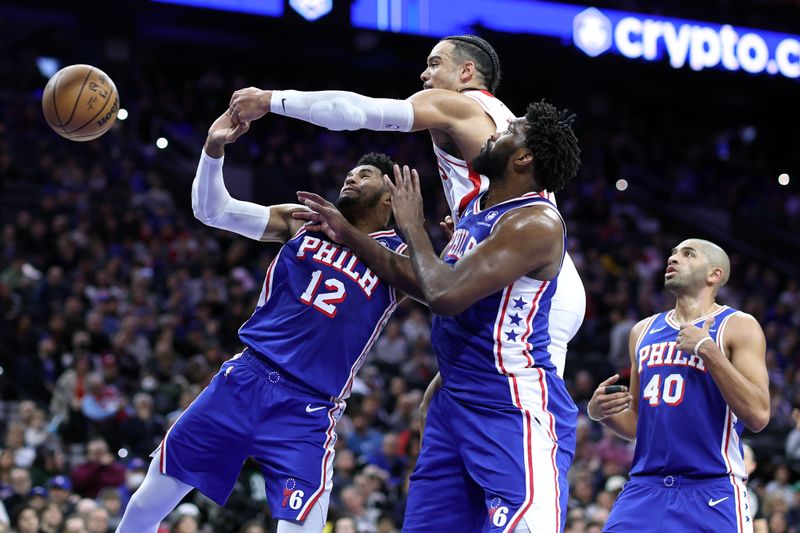 PHILADELPHIA, PENNSYLVANIA - JANUARY 15: Dillon Brooks #9 challenges for the ball over Tobias Harris #12 and Joel Embiid #21 of the Philadelphia 76ers during the second quarterat the Wells Fargo Center on January 15, 2024 in Philadelphia, Pennsylvania. NOTE TO USER: User expressly acknowledges and agrees that, by downloading and or using this photograph, User is consenting to the terms and conditions of the Getty Images License Agreement. (Photo by Tim Nwachukwu/Getty Images)