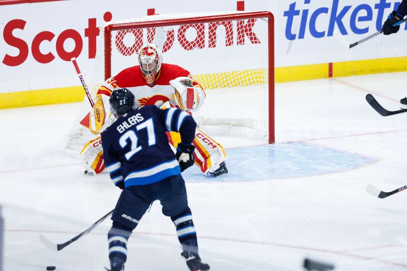 Oct 2, 2024; Winnipeg, Manitoba, CAN;  Winnipeg Jets forward Nikolaj Ehlers (27) skates in on Calgary Flames goalie Dustin Wolf (32) during the third period at Canada Life Centre. Mandatory Credit: Terrence Lee-Imagn Images