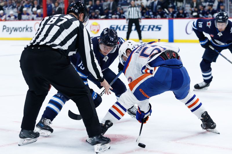 Sep 25, 2024; Winnipeg, Manitoba, CAN; Winnipeg Jets forward Rasmus Kupari (15) faces off against Edmonton Oilers forward James Hablin (52) during the second period at Canada Life Centre. Mandatory Credit: Terrence Lee-Imagn Images