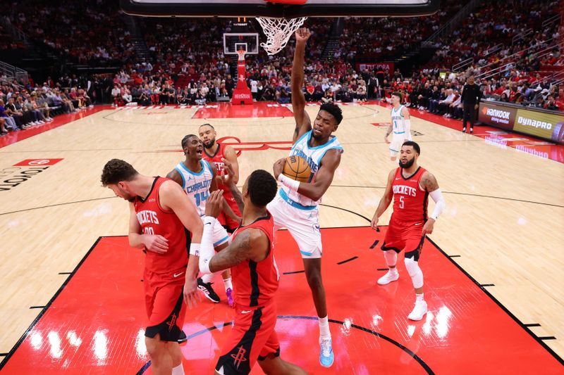 HOUSTON, TEXAS - OCTOBER 23: Brandon Miller #24 of the Charlotte Hornets slam dunks the ball over Alperen Sengun #28 of the Houston Rockets and Jabari Smith Jr. #10 during the first half at Toyota Center on October 23, 2024 in Houston, Texas.  NOTE TO USER: User expressly acknowledges and agrees that, by downloading and or using this photograph, User is consenting to the terms and conditions of the Getty Images License Agreement. (Photo by Alex Slitz/Getty Images)