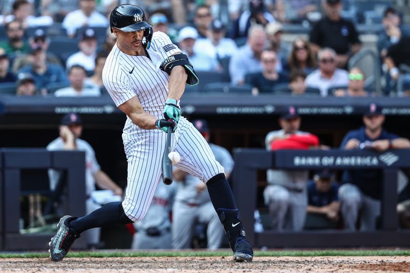 Sep 15, 2024; Bronx, New York, USA;  New York Yankees designated hitter Giancarlo Stanton (27) hits a RBI sacrifice fly in the seventh inning against the Boston Red Sox at Yankee Stadium. Mandatory Credit: Wendell Cruz-Imagn Images