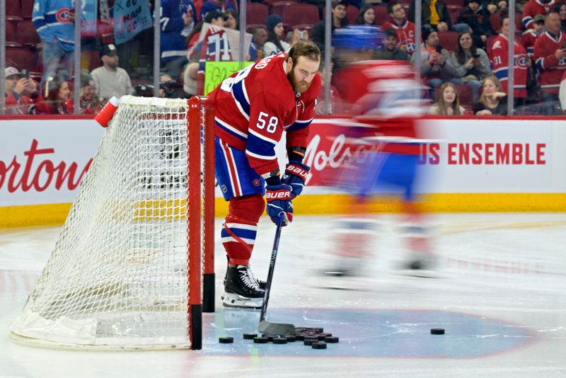 Mar 9, 2024; Montreal, Quebec, CAN;Montreal Canadiens defenseman David Savard (58) clears pucks from the net  during the warm up period before the game against the Toronto Maple Leafs at the Bell Centre. Mandatory Credit: Eric Bolte-USA TODAY Sports