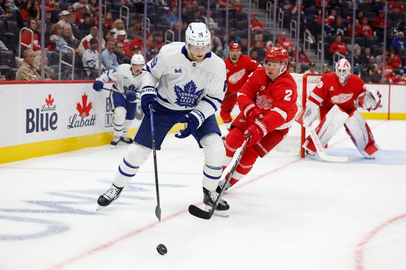 Oct 3, 2024; Detroit, Michigan, USA;  Toronto Mable Leafs center Steven Lorentz (18) skates with the puck against Detroit Red Wings defenseman Olli Maatta (2) in the first period at Little Caesars Arena. Mandatory Credit: Rick Osentoski-Imagn Images