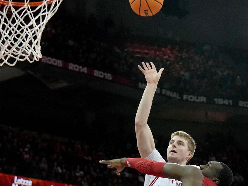 Jan 6, 2024; Madison, Wisconsin, USA; Wisconsin forward Steven Crowl (22) scores on Nebraska forward Juwan Gary (4) during the second half of their game at Kohl Center. Mandatory Credit: Mark Hoffman-USA TODAY Sports