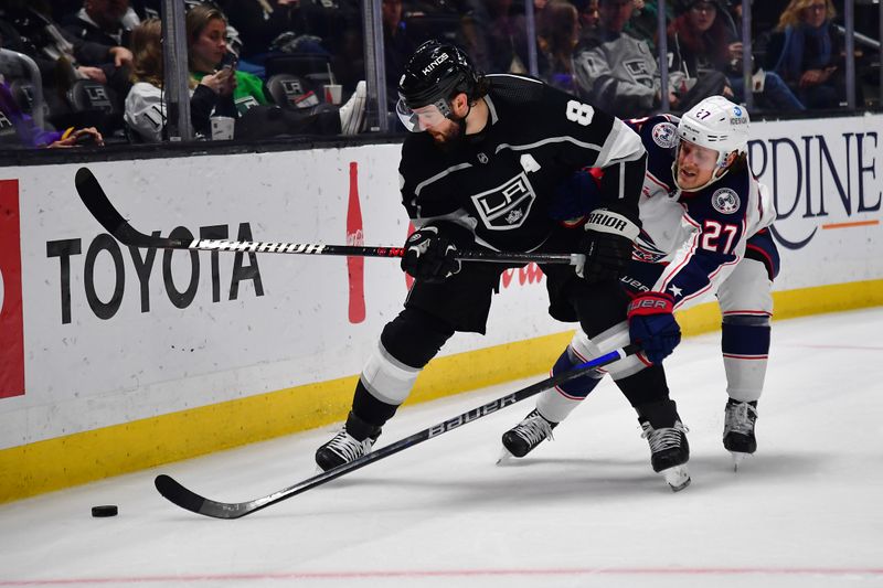 Mar 16, 2023; Los Angeles, California, USA; Los Angeles Kings defenseman Drew Doughty (8) plays for the puck against Columbus Blue Jackets defenseman Adam Boqvist (27) during the third period at Crypto.com Arena. Mandatory Credit: Gary A. Vasquez-USA TODAY Sports