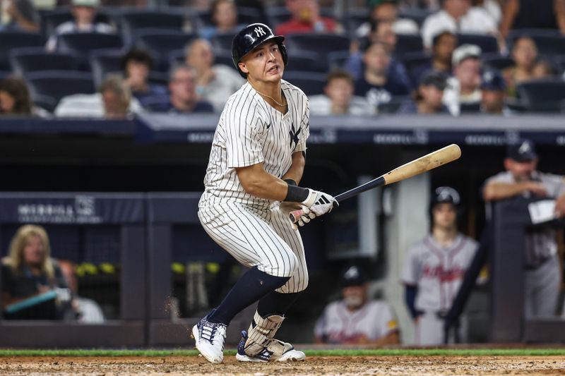 Jun 22, 2024; Bronx, New York, USA;  New York Yankees shortstop Anthony Volpe (11) hits a double against the Atlanta Braves in the sixth inning at Yankee Stadium. Mandatory Credit: Wendell Cruz-USA TODAY Sports