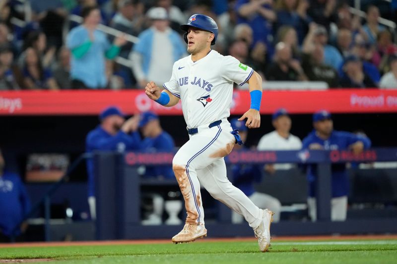 Apr 16, 2024; Toronto, Ontario, CAN; Toronto Blue Jays center fielder Daulton Varsho (25) scores on a single hit by first baseman Vladimir Guerrero Jr. (not pictured) during the fourth inning against the New York Yankees  at Rogers Centre. Mandatory Credit: John E. Sokolowski-USA TODAY Sports