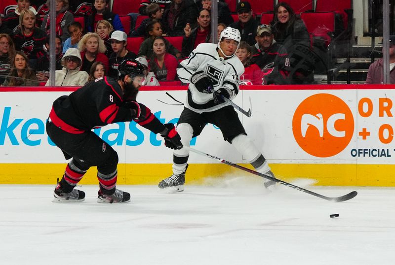 Jan 15, 2024; Raleigh, North Carolina, USA;  Los Angeles Kings right wing Quinton Byfield (55) takes a shot past Carolina Hurricanes defenseman Brent Burns (8) during the second period at PNC Arena. Mandatory Credit: James Guillory-USA TODAY Sports