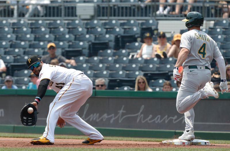 Jun 7, 2023; Pittsburgh, Pennsylvania, USA;  Oakland Athletics shortstop Kevin Smith (4) reaches first base on an infield single as the throw pulls Pittsburgh Pirates first baseman Carlos Santana (41) off of the base during the first inning at PNC Park. Mandatory Credit: Charles LeClaire-USA TODAY Sports