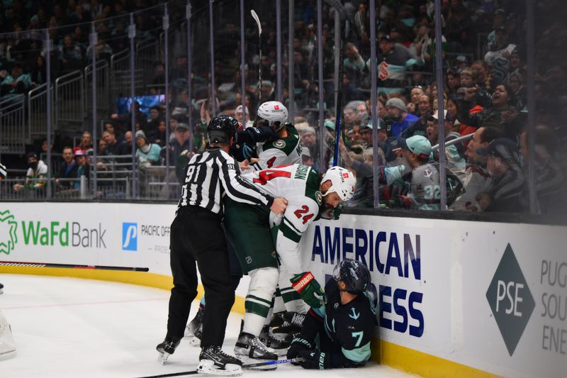 Dec 10, 2023; Seattle, Washington, USA; Minnesota Wild defenseman Zach Bogosian (24) reaches down to help Seattle Kraken right wing Jordan Eberle (7) after checking Eberle into the wall during the second period at Climate Pledge Arena. Mandatory Credit: Steven Bisig-USA TODAY Sports