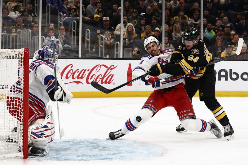 Nov 28, 2025; Boston, Massachusetts, USA; Boston Bruins left wing Tanner Jeannot (84) battles for the puck with New York Rangers defenseman Matthew Robertson (29) in front of goaltender Igor Shesterkin (31) during the third period at TD Garden. Mandatory Credit: Winslow Townson-Imagn Images