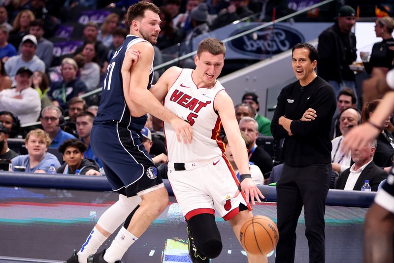 DALLAS, TEXAS - MARCH 07: Nikola Jovic #5 of the Miami Heat drives to the basket against Luka Doncic #77 of the Dallas Mavericks in the first half at American Airlines Center on March 07, 2024 in Dallas, Texas.  NOTE TO USER: User expressly acknowledges and agrees that, by downloading and or using this photograph, User is consenting to the terms and conditions of the Getty Images License Agreement. (Photo by Tim Heitman/Getty Images)