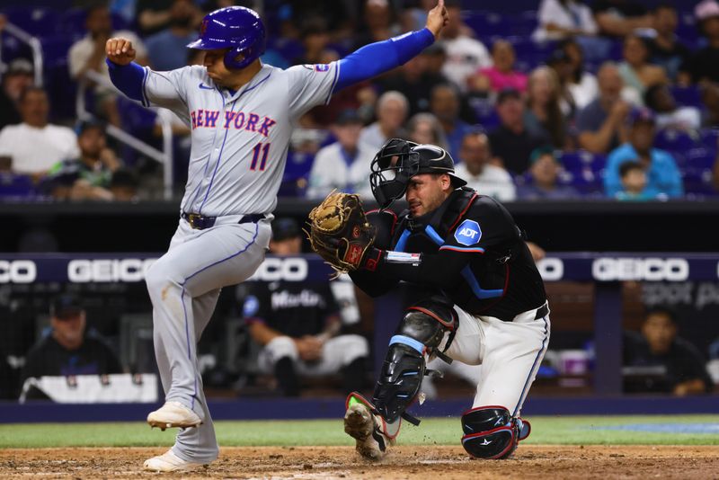 Jul 19, 2024; Miami, Florida, USA; Miami Marlins catcher Nick Fortes (4) tags New York Mets second baseman Jose Iglesias (11) out at home plate during the eighth inning at loanDepot Park. Mandatory Credit: Sam Navarro-USA TODAY Sports