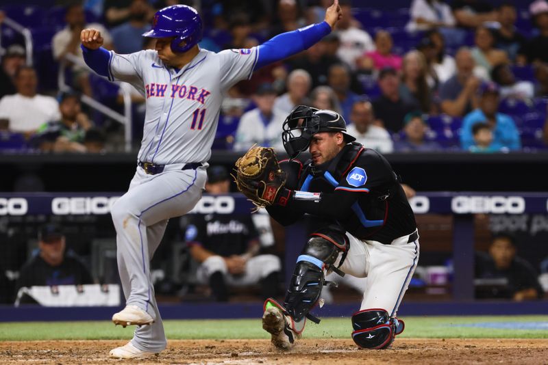 Jul 19, 2024; Miami, Florida, USA; Miami Marlins catcher Nick Fortes (4) tags New York Mets second baseman Jose Iglesias (11) out at home plate during the eighth inning at loanDepot Park. Mandatory Credit: Sam Navarro-USA TODAY Sports