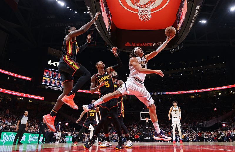 ATLANTA, GEORGIA - DECEMBER 11:  Aaron Gordon #50 of the Denver Nuggets drives to the basket against Onyeka Okongwu #17 and Dejounte Murray #5 of the Atlanta Hawks during the second half at State Farm Arena on December 11, 2023 in Atlanta, Georgia.  NOTE TO USER: User expressly acknowledges and agrees that, by downloading and/or using this photograph, user is consenting to the terms and conditions of the Getty Images License Agreement.  (Photo by Kevin C. Cox/Getty Images)