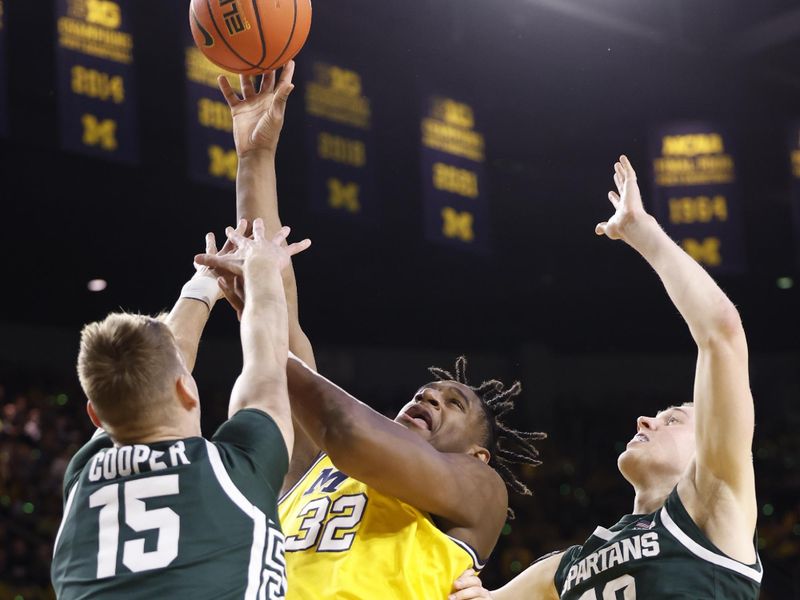 Feb 18, 2023; Ann Arbor, Michigan, USA;  Michigan Wolverines forward Tarris Reed Jr. (32) shoots the ball against Michigan State Spartans center Carson Cooper (15) and forward Joey Hauser (10) in the first half at Crisler Center. Mandatory Credit: Rick Osentoski-USA TODAY Sports