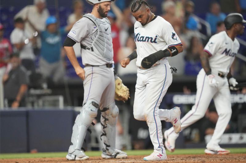 May 2, 2024; Miami, Florida, USA;  Miami Marlins second baseman Luis Arraez (3) scores the winning run in the tenth inning as Colorado Rockies catcher Jacob Stallings (25) looks on at loanDepot Park. Mandatory Credit: Jim Rassol-USA TODAY Sports