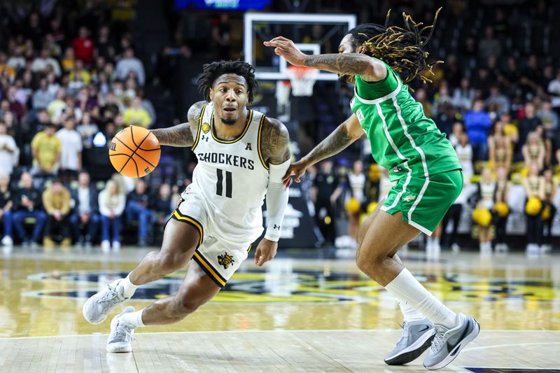 Jan 29, 2025; Wichita, Kansas, USA; Wichita State Shockers guard Justin Hill (11) drives to the basket around North Texas Mean Green guard Rondel Walker (5) during the second half at Charles Koch Arena. Mandatory Credit: William Purnell-Imagn Images