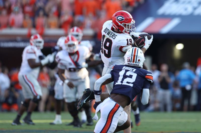 Sep 30, 2023; Auburn, Alabama, USA; Georgia Bulldogs tight end Brock Bowers (19) makes a catch as Auburn Tigers safety Caleb Wooden (12) closes in during the fourth quarter at Jordan-Hare Stadium. Mandatory Credit: John Reed-USA TODAY Sports