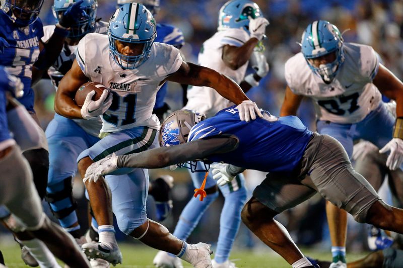 Oct 13, 2023; Memphis, Tennessee, USA; Tulane Green Wave running back Makhi Hughes (21) runs the ball as Memphis Tigers defensive linemen Zy Brockington (0) attempts to make the tackle during the second half at Simmons Bank Liberty Stadium. Mandatory Credit: Petre Thomas-USA TODAY Sports