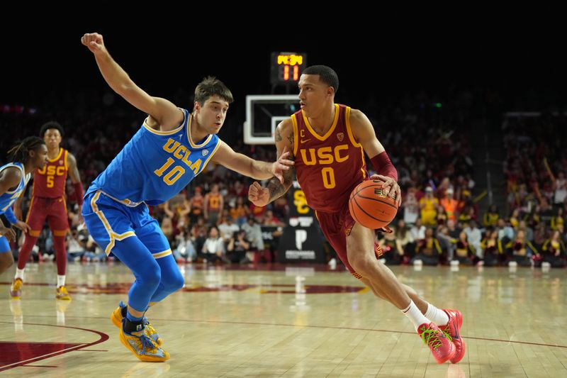 Jan 27, 2024; Los Angeles, California, USA; Southern California Trojans guard Kobe Johnson (0) dribbles against UCLA Bruins guard Lazar Stefanovic (10) in the second half at Galen Center. Mandatory Credit: Kirby Lee-USA TODAY Sports