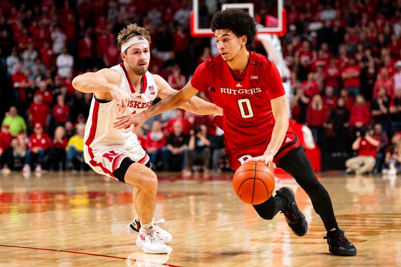 Mar 3, 2024; Lincoln, Nebraska, USA; Rutgers Scarlet Knights guard Derek Simpson (0) drives against Nebraska Cornhuskers guard Sam Hoiberg (1) during the second half at Pinnacle Bank Arena. Mandatory Credit: Dylan Widger-USA TODAY Sports