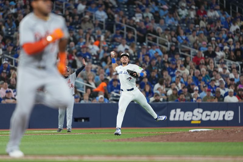 May 18, 2025; Toronto, Ontario, CAN; Toronto Blue Jays third baseman Addison Barger (47) fakes a throw to first base as Detroit Tigers pinch hitter Andy Ibanez (77) gets on base for a single during the seventh inning at Rogers Centre. Mandatory Credit: Nick Turchiaro-Imagn Images