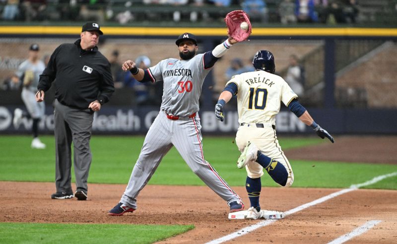 Apr 3, 2024; Milwaukee, Wisconsin, USA; Milwaukee Brewers center fielder Sal Frelick (10) beats a throw to Minnesota Twins first baseman Carlos Santana (30) in the first inning at American Family Field. Mandatory Credit: Michael McLoone-USA TODAY Sports