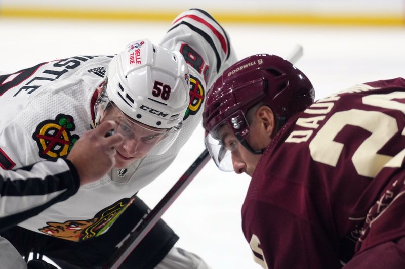 Mar 18, 2023; Tempe, Arizona, USA; Chicago Blackhawks right wing MacKenzie Entwistle (58) and Arizona Coyotes center Laurent Dauphin (26) face off during the first period at Mullett Arena. Mandatory Credit: Joe Camporeale-USA TODAY Sports