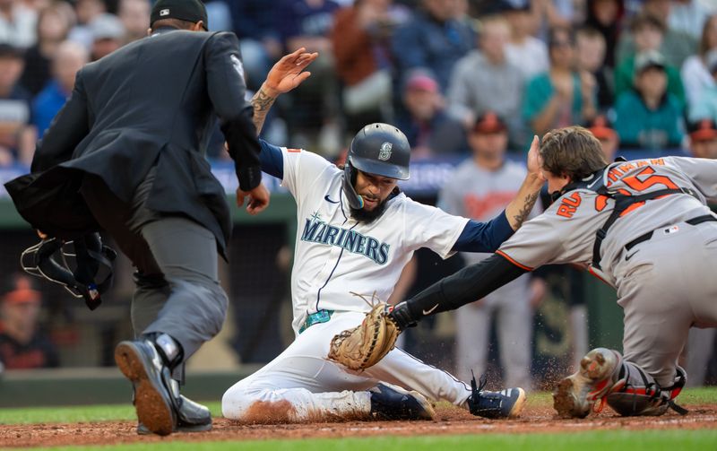Jun 4, 2025; Seattle, Washington, USA;  Seattle Mariners shortstop J.P. Crawford (3) is tagged out by Balitimore Orioles catcher Adley Rutschman (35) during the sixth inning at T-Mobile Park. Mandatory Credit: Stephen Brashear-Imagn Images