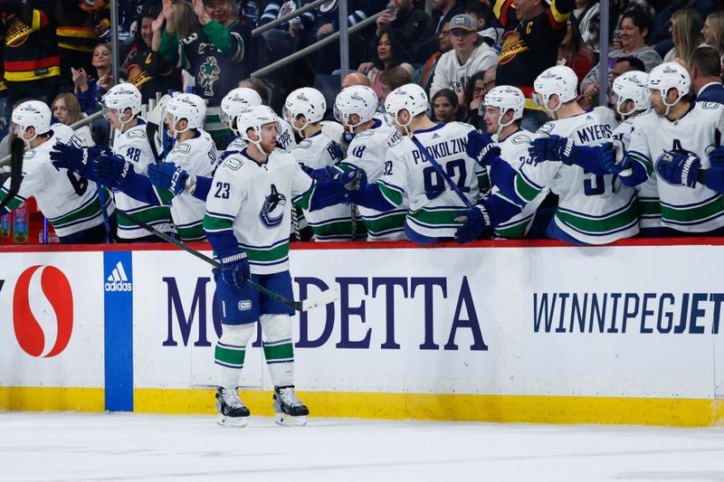 Apr 18, 2024; Winnipeg, Manitoba, CAN;  Vancouver Canucks forward Elias Lindholm (23) is congratulated by his team mates on his goal against the Winnipeg Jets during the second period at Canada Life Centre. Mandatory Credit: Terrence Lee-USA TODAY Sports